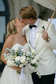 a bride and groom kissing under an umbrella