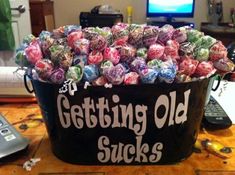 a large bucket filled with candy sitting on top of a table next to a computer