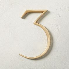 the number five is shown in gold on a white wall