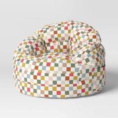 a bean bag chair with multicolored squares on the top and bottom, sitting in front of a white background