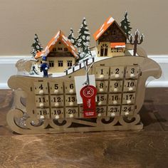 a wooden calendar with houses and trees on it