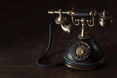 an old fashioned phone sitting on top of a wooden floor