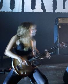 two women are playing guitars on stage