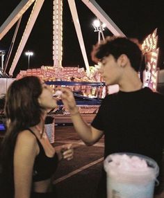 two people eating food at an amusement park