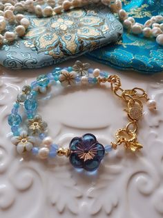 Delightful selection of Springtime soft blue & white tones in in this Bohemian Beaded bracelet. This bracelet has been made with love and I have used assorted selection of super cute Czech glass beads, including these super cute Czech Pansy flowers, some pearls, Aqua blue Agate Rondelles and the most gorgeous Blue Frangipani focal bead. To add to the theme of Springtime I have added a super cute Gold Vermeil Bee charm as well. I have also used pretty gold  CZ clasp and included a extender chain Handmade Light Blue Beaded Bracelets, Unique Handmade Blue Beaded Bracelets, Unique Blue Beaded Bangle Bracelets, Light Blue Beaded Flower Jewelry, Blue Bohemian Crystal Bracelet With Round Beads, Light Blue Flower-shaped Beaded Jewelry, Blue Beaded Bohemian Crystal Bracelet, Blue Unique Beaded Bracelets, Handmade Flower Shaped Blue Beaded Bracelets