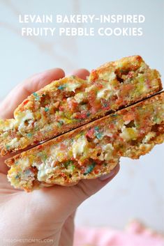 a person holding up a piece of fruity pebble cookies