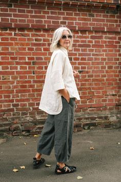 "These tapered linen pants are made to order. Made of soft organic linen it features a wide leg fit, elastic waistband and side pockets. The pants have a cinched, high waist balanced by legs that barrel gently and taper towards the bottom.  PANTS DETAILS ⚬ Elastic waistband ⚬ Side pockets ⚬ Made of washed organic Oeko-Tex certified linen . ⚬ Linen is NOT see-through. ⚬ The fabric is prewashed to guarantee no shrinkage. ⚬ The color of the pants on the picture \"graphite\".  FIT/SIZE ⚬ Sizes XXS t Linen Tapered Pants Outfit, Work Linen Pants Outfit, No Waist Outfits, Relaxed Womens Outfits, Loose Clothing Style For Women, Linen Pants Styling, Tomboy Femme Outfits Summer, Styling Wide Leg Linen Pants, Linen Palazzo Pants Outfit