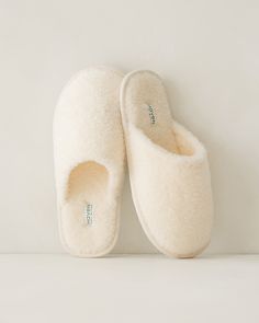 a pair of slippers sitting on top of a white wall