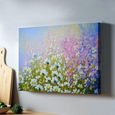 a painting on the wall above a wooden cutting board