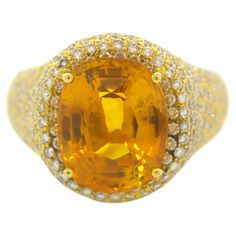 A lovely gem quality orange sapphire takes center stage! It weighs an impressive 8.40 carats and has a vibrant brilliant orange color with no visible inclusions. It is complemented by 4.22 carats of round brilliant pave-set diamonds set around the 18k yellow gold ring. Certified by the GIA as natural and ready to be worn. Ring Size 7.75 Weight: 11 grams Diamond Gold Ring, Orange Sapphire, 18k Yellow Gold Ring, Diamond Gold, Gold Diamond Rings, Center Stage, Sapphire Diamond, Round Brilliant, Gold Ring