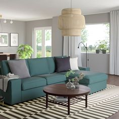 a living room filled with furniture and a rug on top of a hard wood floor