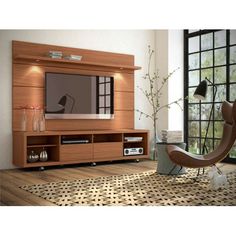 a living room with a large tv on top of a wooden entertainment center next to a window