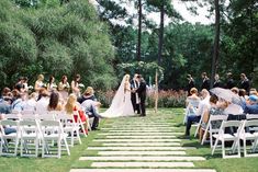 a bride and groom standing at the end of a set of steps in front of an outdoor ceremony