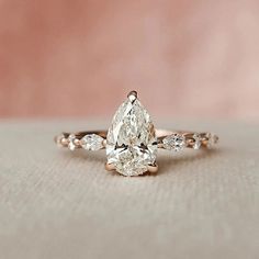 a pear shaped diamond engagement ring with three side stones