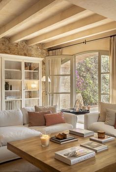 a living room filled with furniture and a wooden coffee table in front of a window