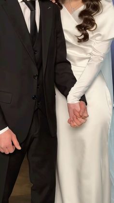 a bride and groom are holding hands