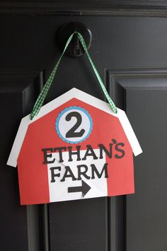 a red barn shaped door hanger with the number two on it