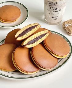 there are many pancakes on the plate with chocolate frosting and cookies in the background