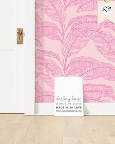 a pink wallpaper with leaves on it next to a white door and wooden floor