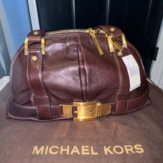 Nwt Michael Kors Sutton Large Belted Satchel Purse In Coffee/Brown Is A Stylish And Spacious Accessory For Women. The Bag Features A Zip Closure And A Brown Leather Handle/Strap, Along With Gold Hardware Accents And Gold Buckle That Add A Touch Of Sophistication. Measuring 7 Inches In Bag Width, 9.5 Inches In Bag Height, 7 Inches In Handle Height. This Satchel/Top Handle Bag Is Perfect For Everyday Use. Made Of Genuine Leather, This Bag Is Durable And High-Quality. The Exterior Color Is Brown, A Luxury Brown Michael Kors Shoulder Bag, Designer Brown Shoulder Bag With Brass Hardware, Designer Brown Shoulder Bag With Gold-tone Hardware, Designer Brown Shoulder Bag With Metal Hardware, Chic Michael Kors Brown Shoulder Bag, Designer Michael Kors Shoulder Bag For Office, Formal Brown Michael Kors Bag, Coffee Brown Color, Practical Bag