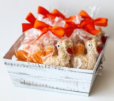 some kind of food in a box with orange bows on the top and two birds