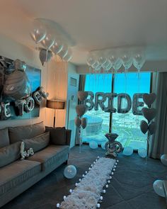 balloons and streamers are on the floor in front of a large window that reads bride