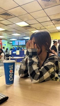 a woman sitting at a table covering her face