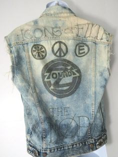 Vintage Levi's Distressed British Punk Jean Vest!We believe that this was a Levi Strauss jacket from the 1980s (70507-0227) that's been cut and marked up celebrating late 70s (1977-1979) punk bands with the following phrases: The Zoundz, The Cravats, Icons of Filth, The Mob. Really quite a work of art.   Men's XS Extra Small - Deep Blue Marbled Denim Measurements: 23" top to bottom :: 19" pit to pit :: 18" shoulder to shoulder :: Condition::Thrashed, distressed, torn and marked up with marker. T Spring Punk Streetwear Vest, Spring Punk Denim Vest For Streetwear, Punk Sleeveless Denim Vest For Streetwear, Grunge Graphic Print Vest For Streetwear, Cotton Grunge Denim Vest For Streetwear, Edgy Cotton Denim Vest For Summer, Vintage Denim Jacket For Summer Streetwear, Punk-style Distressed Cotton Denim Jacket, Faded Distressed Grunge Denim Jacket