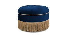 a blue ottoman with tassels and fringe on the bottom, sitting in front of a white background