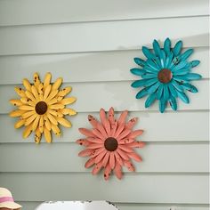 three sunflowers are hanging on the wall