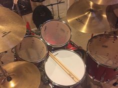 a drum set up with drums and sticks in front of it on the carpeted floor