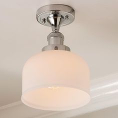 a light fixture with a white glass shade