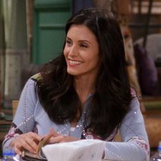 a woman sitting at a table with a plate in front of her and looking to the side