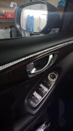 the inside of a car with its door handle down and a mirror in the center