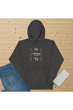 Chacoal heather hoodie spread out on beige background with jeans and mobile. White design it is up to you in Hebrew blockletters. 3 words in 3 rows. The text is between outlined  arrows pointing upwards. Approx total design size 8 x 8 inches Sea Isle City, Kure Beach, Beach Surf, Motivational Phrases, Timeless Style, Destiny