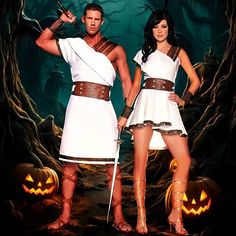 a man and woman dressed in roman costumes with pumpkins on the ground behind them