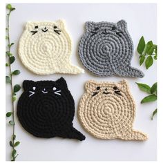 four crocheted coasters with cats on them and one cat sitting in the middle