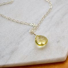 Our zesty yellow Limoncello Necklace has just the right balance of sweet and tart. Ciao, ciao! This Lemon Quartz necklace is a classic solitaire design featuring a faceted gemstone in a refreshing yellow hue. We hand wire wrap your Lemon Quartz gem in our signature tightrope style and anchor the gem pendant on a classic chain (with a little shimmer to it). Effortlessly simple necklace; closed securely with a spring-ring clasp. Choose from affordable Gold Fill, shiny or black oxidized Sterling Si Lemon Quartz Necklace, Minimalist Jewelry Earrings, Gem Pendant, Yellow Quartz, Solitaire Necklace, White Gold Chains, Solitaire Necklaces, Demi Fine Jewelry, Lemon Quartz