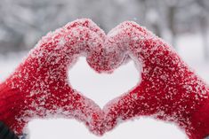 two hands in the shape of a heart are covered with snow as if they were making a hand gesture