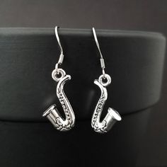 SAXOPHONE EARRINGS - Beautiful silver plated saxophone charm earrings Size of saxophone charm: 22x11mm MATERIAL: Lead free, nickel free, This set makes a perfect gift for any saxophonist, marching band member or music teacher. Silver Music-themed Metal Jewelry, Music-themed Silver Metal Jewelry, Silver Music-themed Charm Jewelry, Silver Music-themed Jewelry With Charms, Nickel-free Metal Music-themed Jewelry, Nickel-free Music-themed Metal Jewelry, Silver Music-themed Jewelry For Party, Music-themed Silver Jewelry For Parties, Silver Nickel-free Music-themed Earrings