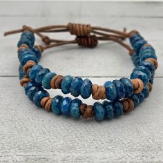 Rustic brown leather and blue Apatite gemstone stacking bracelets. The Apatite stones are faceted and have a beautiful deep blue color. These bracelets look great alone or stacked together and with other bracelets. The classic look of gemstones with modern and edgy leather. Groups of three gemstones knotted together around a leather bracelet. Finished with a sliding knot clasp. The clasp adjusts to help you get the perfect fit. Slide the leather knot over the bracelet straps to open up the brace Adjustable Hand Wrapped Blue Leather Bracelet, Adjustable Blue Leather Bracelets, Adjustable Blue Leather Bracelet, Blue Leather Bracelet For Gifts, Blue Leather Bracelet As Gift, Adjustable Blue Leather Bracelet For Everyday, Everyday Blue Leather Jewelry, Rustic Adjustable Blue Bracelets, Rustic Blue Adjustable Beaded Bracelets