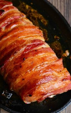 ham wrapped in bacon is cooking in a skillet on the stove top, ready to be cooked