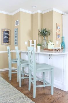 a dining room table with four chairs and a kitchen island in the middle of it