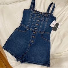 Denim Romper With Button Closure Down The Front. New With Tags, Size Xs. Fits True To Size. Adjustable Straps. High Rise Cotton Denim Jumpsuit With Button Closure, High-rise Cotton Denim Jumpsuit With Button Closure, Medium Wash Denim Jumpsuit With Buttons, High Waist Medium Wash Denim Jumpsuit With Button Closure, Casual Denim Blue Jumpsuit With Buttons, High-waist Medium Wash Denim Jumpsuit With Button Closure, Casual Dark Wash Denim Jumpsuit With Buttons, Denim Button-up Overalls With Buttons, Button-up Denim Overalls With Buttons