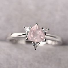 ◆ The ring is handcrafted from sterling silver and decorated with a dazzling 6*6 mm rose quartz and CZs. It is suitable for engagement/anniversary/daily occasion. ◆ Production Description: Main stone Type: Natural Rose Quartz Main Stone Shape: Trillion Cut Main Stone Size: 6*6 mm(0.85ct) Side stone: CZ Metal: 925 Sterling silver - Other options available in the drop down menu ◆ Customization: √Free for Add Engraving √Other Metal Type Available √Other Gemstones & Shapes Available √Personaliza Promise Ring With Rose Quartz And Gemstone Detail, Rose Sterling Silver Wedding Rings, Wedding Rings In Rose Sterling Silver, Elegant Pink Birthstone Ring In Sterling Silver, Elegant Pink Sterling Silver Birthstone Ring, Wedding Rose Gold Birthstone Ring In Sterling Silver, Elegant Pink Birthstone Ring With Diamond Accents, Rose Diamond Jewelry For Wedding, Rose Diamond Wedding Jewelry