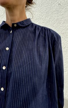 A button collared shirt in a featherweight soft khadi cotton with button sleeve. Tuck it in or wear it out. It's so very chic! shell buttons Made in the NY garment District using artisan fabrics. Color: Navy Pinstripe — handwoven cotton, length 30" with sleeve — Length 27" flat — one size — shell buttons Navy Button-up Top With Buttons, Striped Button-up Blouse With Placket, Button Collar Shirt, Indigo Button-up Cotton Shirt, Striped Button-up Tops With Button Closure, Indigo Button-up Top With Button Closure, Suede Coat, Caftan Dress, Shell Buttons