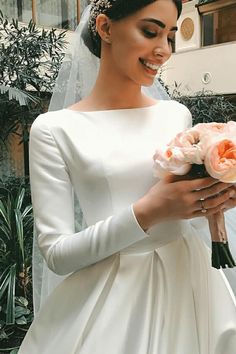 a woman in a wedding dress holding flowers