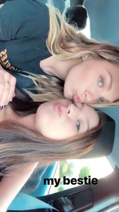 two beautiful young women sitting next to each other in the back seat of a car