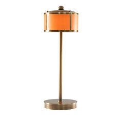 a lamp that is sitting on top of a metal stand with an orange shade over it