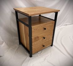 a wooden cabinet with two drawers on one side and black metal frame around the top